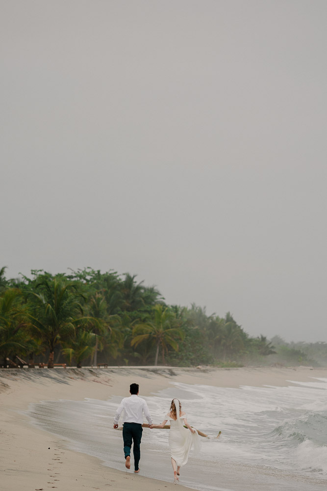 A bride and groom running on the beach after their destination wedding in Santa Marta Colombia