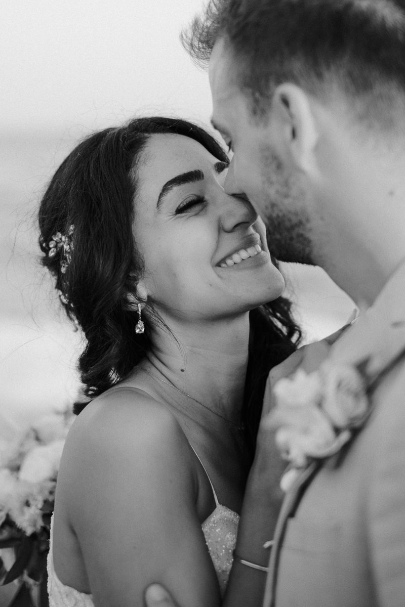 newly married couple kissing on the beach in tenerife and laughing by tenerife wedding photographer
