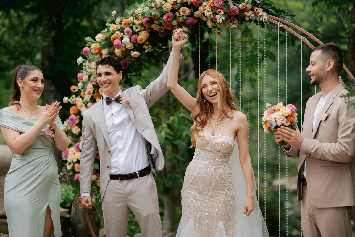 Couple celebrating their wedding in the Canary islands in front of friends and family and beautiful flower arch by tenerife wedding photographer