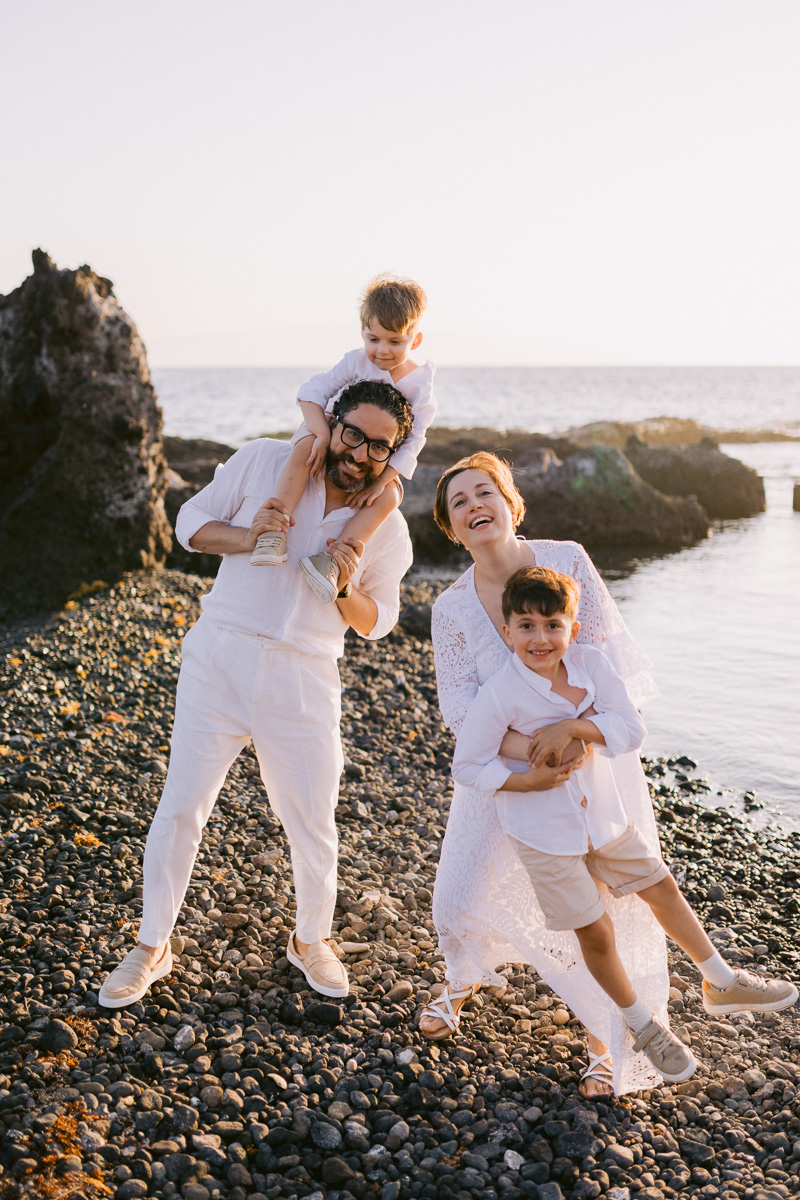 Happy familt of 4 having a photoshoot on the beach in Tenerife

