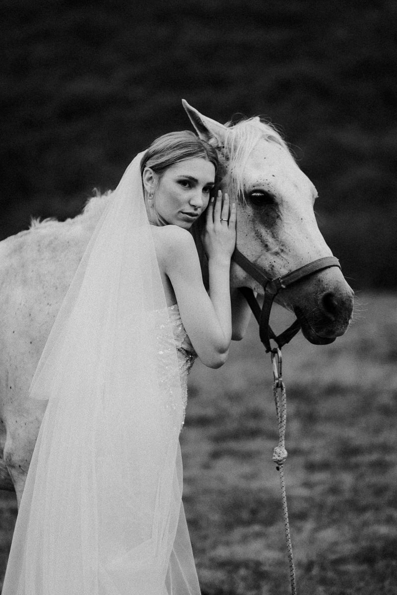 Bride posing with a horse, looking at the camera by tenerife wedding photographer
