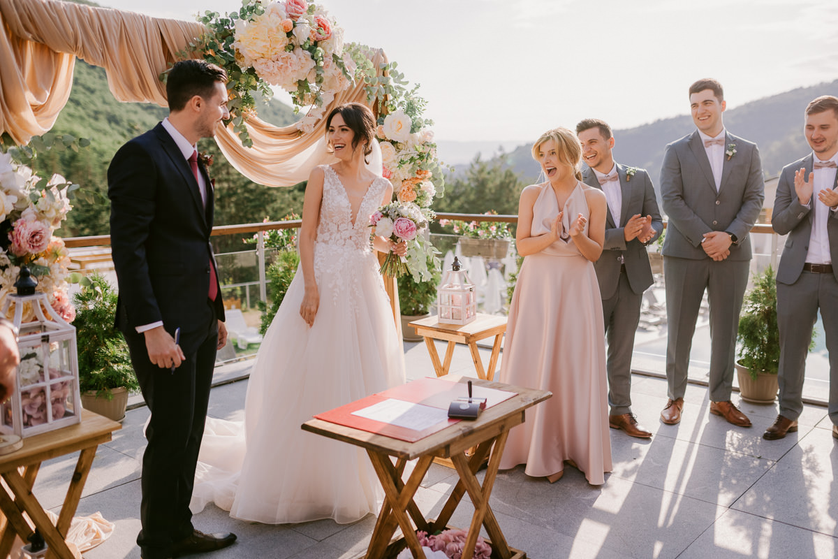 bride and groom with their guests laughing during their wedding ceremony in a beautiful setting by tenerife wedding photographer Kristina